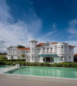 ein großes weißes Herrenhaus mit einem Pool in der Unterkunft Macalister Mansion, a Member of Design Hotels in George Town
