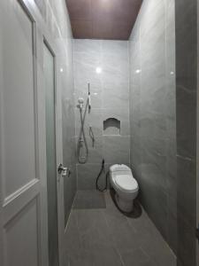 a bathroom with a shower and a toilet in it at Hotel Artha in Tjakranegara
