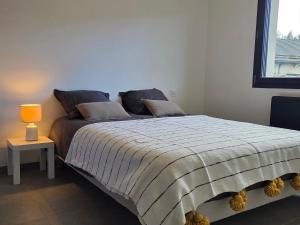 a bedroom with a bed and a lamp on a table at Le chalet du Petit Ours Brun in Formiguères