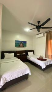 カンポン・ペナリックにあるAG Suitesのベッド2台と天井ファン付きの寝室