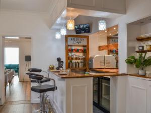 a kitchen with a counter and a bar stool at Kilburn House in Bridlington +42 photos