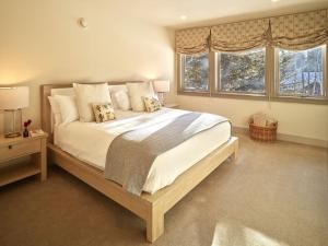 a bedroom with a large bed and two windows at RMR: Sublette Ridge Ski Lodge in Teton Village in Teton Village
