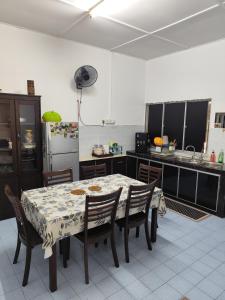 テメルローにあるAHA Homestay Temerloh with 3 bedrooms, 2 toiletのテーブルと椅子と冷蔵庫のあるキッチン