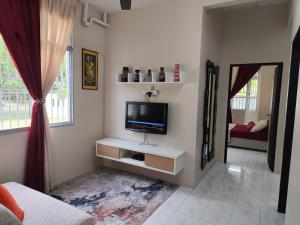 a living room with a tv on a wall at AHA Homestay Temerloh with 3 bedrooms, 2 toilet in Temerloh