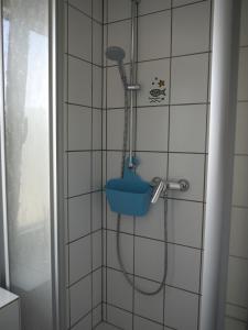 a shower with a blue bucket in a bathroom at Punkrock Harbour Pension Bähr in Karlsruhe