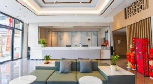 een woonkamer met een bank en een tafel bij GreenTree Inn Maanshan Hanshan District Jiuwu Square Hotel in Jiulian