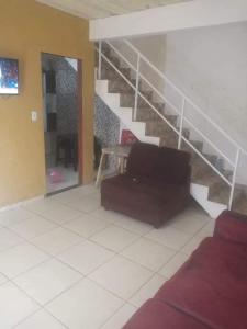 Una sala de estar con un sofá y una escalera. en casa 3 quartos 10 camas jardim marileia, en Rio das Ostras