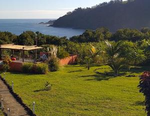 a green field with a view of the ocean at Cap Vanisa, bungalows avec piscine et vue océan à Manapany in Saint-Joseph