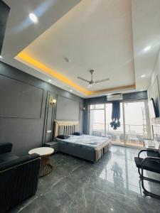 a bedroom with a bed and a couch and a table at Moonrisehomestays in Ghaziabad