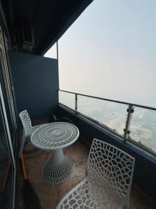 a table and two chairs on a balcony with a view at Moonrisehomestays in Ghaziabad