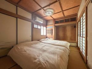 a bedroom with a white bed in a room with windows at 2nd Home Kaminagayoshi in Ichihara