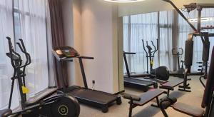 a gym with several treadmills and machines in a room at Ease Hotel Xi'an High-tech Zone 4th Zhangba Road Metro Station in Xi'an