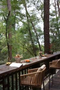 Una terraza de madera con una mesa y dos sillas. en Huangshan Xishui Yunjian Forest Resort Hotel, en Huangshan