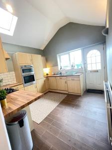 a kitchen with wooden cabinets and a counter top at Newcastle Pet friendly 1 bed drive garden 10m city in Kenton +4 photos