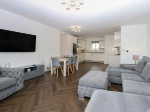 ein Wohnzimmer mit Sofa und Tisch in der Unterkunft 26 Awel Y Mor in Pwllheli