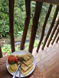 a plate of food on a table on a porch at are twin bungalows in Tetebatu +39 photos