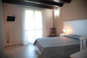 ein Schlafzimmer mit einem Bett und einem großen Fenster in der Unterkunft B & B Korello in Gasponi