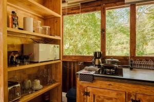eine Küche mit einer Theke und einem Fenster in einer Hütte in der Unterkunft Chalé romântico com banheira aquecida in Nazaré Paulista