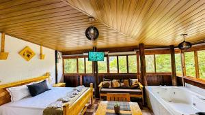 ein Schlafzimmer mit einem Bett und einer Badewanne in der Unterkunft Chalé romântico com banheira aquecida in Nazaré Paulista + 32 Fotos