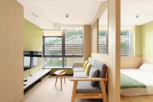 een slaapkamer met een bed, een bank en een stoel bij Urbanwood Ap Lei Chau in Hong Kong