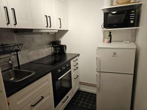 a small kitchen with a sink and a microwave at Liten lägenhet i Smedby, Norrköping in Norrköping