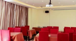 een conferentieruimte met rode stoelen en tafels en een scherm bij GreenTree Inn Nanjing Dachang Getang Metro Station Express Hotel in Dachang
