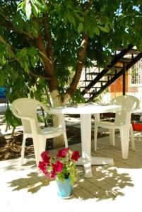 a white table and chairs and flowers on a patio at Guest Нouse in Odesa