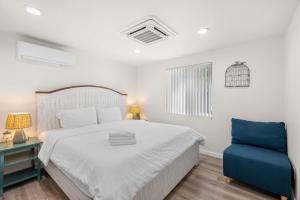 Un dormitorio con una cama y una silla azul. en Foothills LA Hideaway Patio Lounge Work-Friendly, en San Dimas
