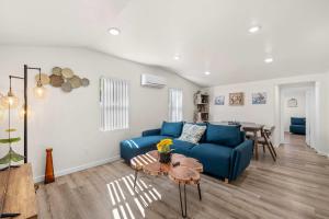 Una sala de estar con un sofá azul y una mesa. en Foothills LA Hideaway Patio Lounge Work-Friendly, en San Dimas