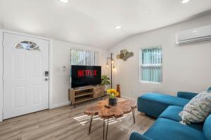 Una sala de estar con un sofá azul y un televisor en Foothills LA Hideaway Patio Lounge Work-Friendly, en San Dimas