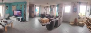 a living room with a couch and a tv at Chambre phare in Auderville