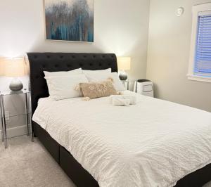 a bedroom with a large bed with white sheets at Casa Del Mar-A family Suite in Victoria in Langford
