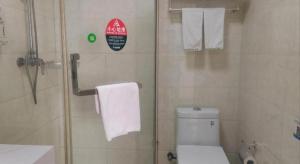 a bathroom with a shower and a toilet and towels at GreenTree Inn Suzhou Wujiang Zhenze Town Zhennan Road Express Hotel in Suzhou +164 photos