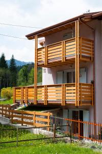 a house with a wooden deck on the side of it at Il Bosco dei 100 Acri in Roncobello
