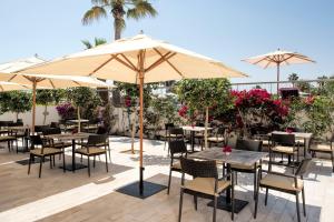 an outdoor patio with tables and chairs and umbrellas at Iberostar Selection Diar El Andalous in Port El Kantaoui
