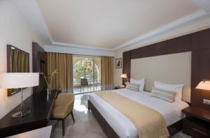 a hotel room with a large bed and a desk and a chair at Iberostar Selection Diar El Andalous in Port El Kantaoui