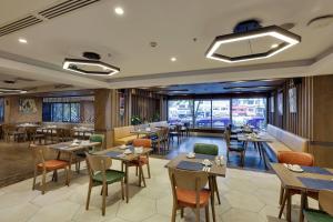 a restaurant with tables and chairs and a large window at Ramada by Wyndham Istanbul Old City in Istanbul