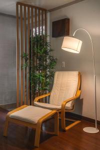 una silla y una lámpara junto a una planta en Ongi Stay, en Busan