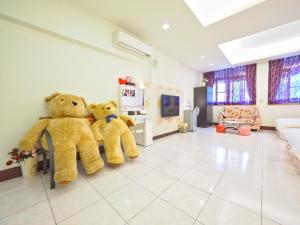 zwei große Teddybären auf einer Bank im Wohnzimmer in der Unterkunft Huadong Homestay in Taitung