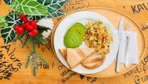 a plate of food with bread and vegetables and a sandwich at Alura Hostel in Kata Beach +21 photos