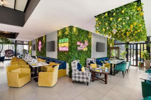 ドーハにあるWyndham Doha West Bayの黄色と青の椅子とテーブルが備わるレストラン