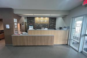 a lobby with a reception desk in a building at AmericInn by Wyndham Hays in Hays