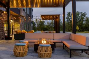 Un patio con un sofá y sillas y una mesa. en Home2 Suites By Hilton Ames, en Ames