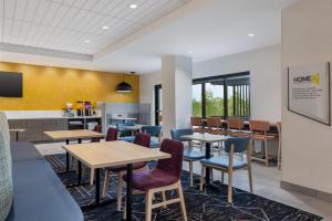una zona de espera con mesas y sillas en una cafetería en Home2 Suites By Hilton Ames, en Ames