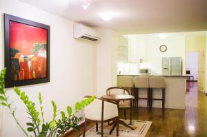 Il comprend un salon avec une table et une cuisine. dans l'établissement Mayfair Hanoi, à Hanoï