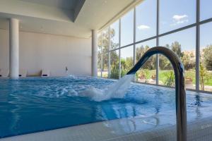 a pool with a water fountain in a building at Iberostar Selection Diar El Andalous in Port El Kantaoui