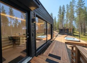 a house with glass doors and a deck with two juzzles at Spa Cabin by Hossaville in Hossa