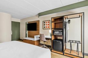 a hotel room with a bed and a desk at Spark by Hilton Lynchburg in Lynchburg