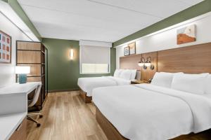 a hotel room with two beds and a desk at Spark by Hilton Lynchburg in Lynchburg +52 photos