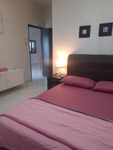 a bedroom with a bed with a red bedspread at Ratu Musleem Homestay in Kuala Selangor +13 photos
